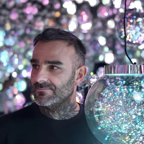 Portrait de Julien Jimenez, expert SEO français, devant un mur de lumières colorées